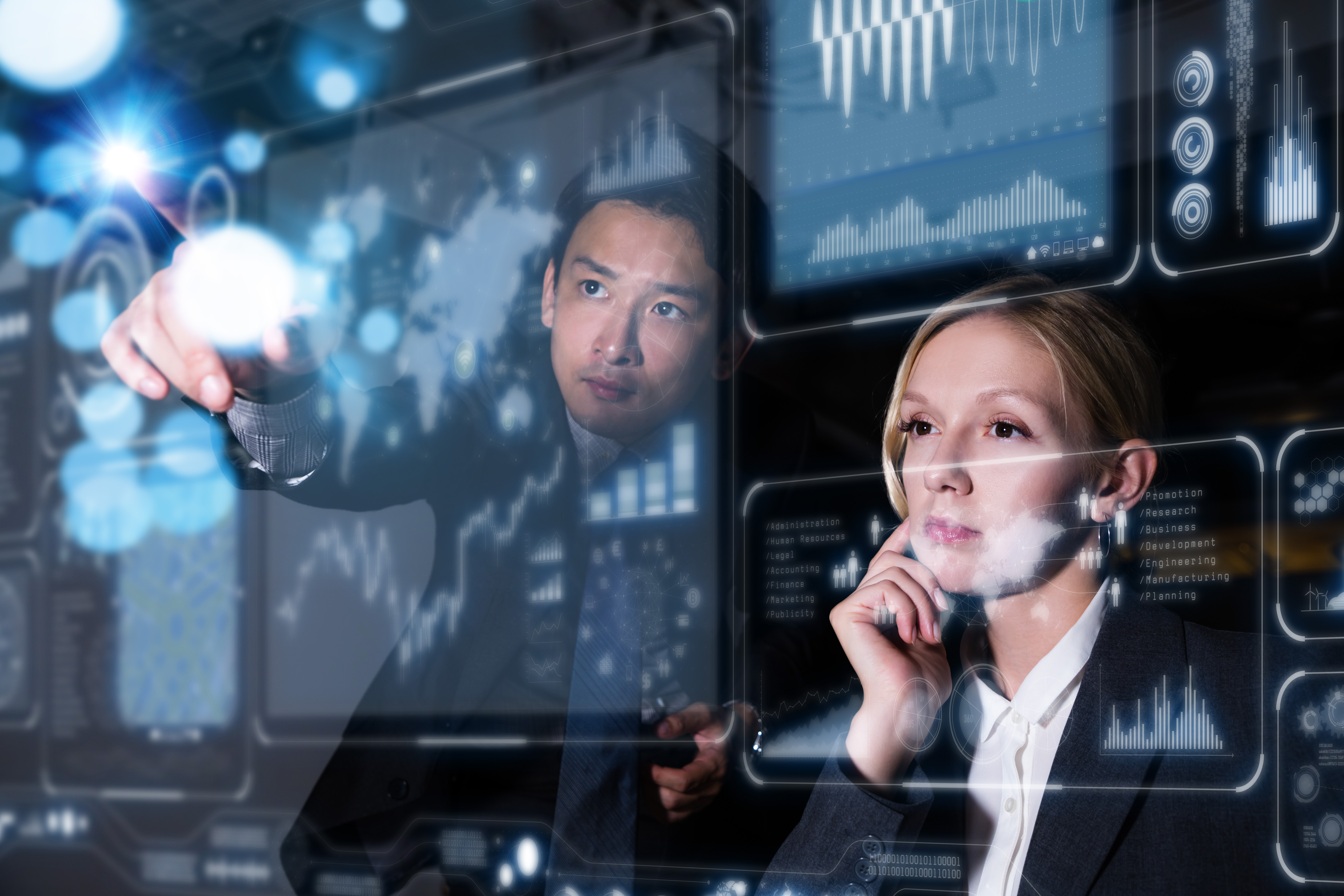 Man and woman pointing at floating computer screens with star systems