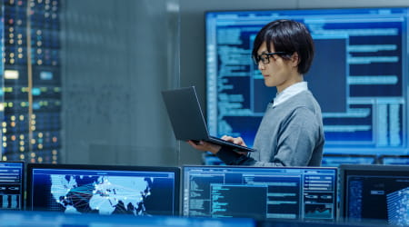 Man with laptop computer surrounded by digital dashboards