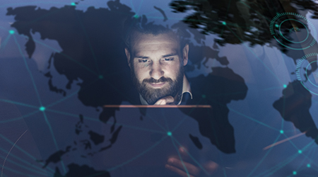 Man looking at computer screen with digital map behind him