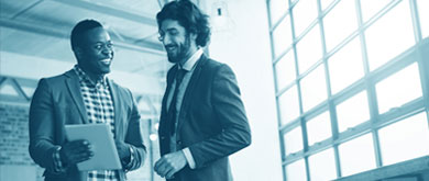 two colleagues discussing something in a notebook