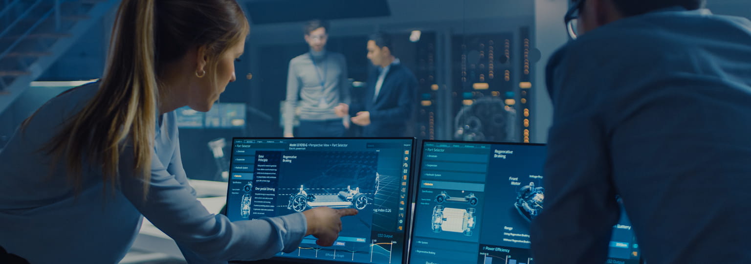 Coworkers look at car model on computer screen