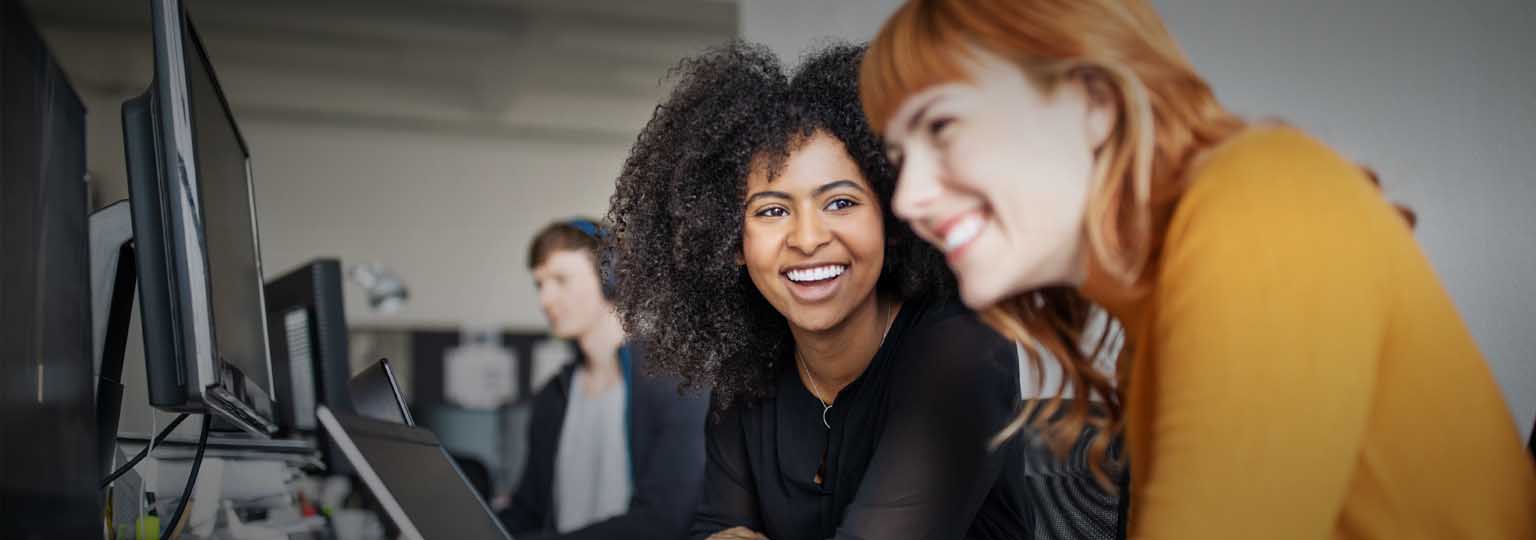 two women smiling while working together