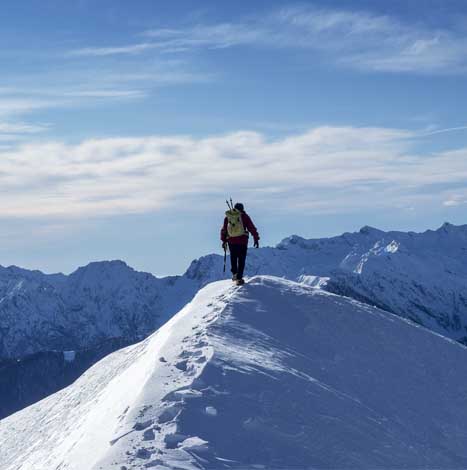 Climber reaching a snowy mountain top