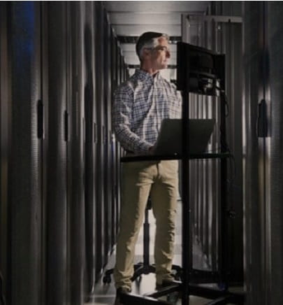 man with laptop in server room